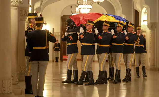 Honor guard soldiers carry the coffin of the late Ion Iliescu, Romania's first freely elected president after the fall of communism in 1989, at the Cotroceni Presidential Palace, in Bucharest, Romania, Wednesday, Aug. 6, 2025.(AP Photo/Vadim Ghirda)