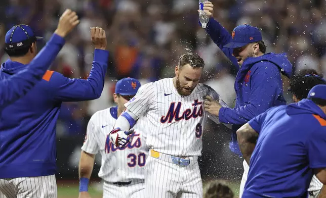 New York Mets' Brandon Nimmo, center, celebrates with teammates after a walk-off win during a baseball game against the Philadelphia Phillies, Tuesday, Aug. 26, 2025, in New York. (AP Photo/Pamela Smith)