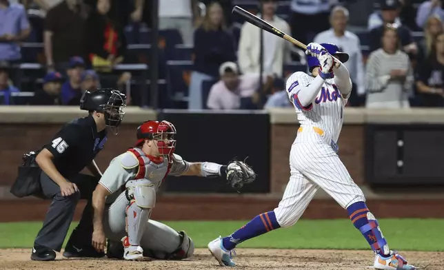 New York Mets' Brandon Nimmo hits a single leading Starling Marte to score during the ninth inning of a baseball game against the Philadelphia Phillies, Tuesday, Aug. 26, 2025, in New York. (AP Photo/Pamela Smith)