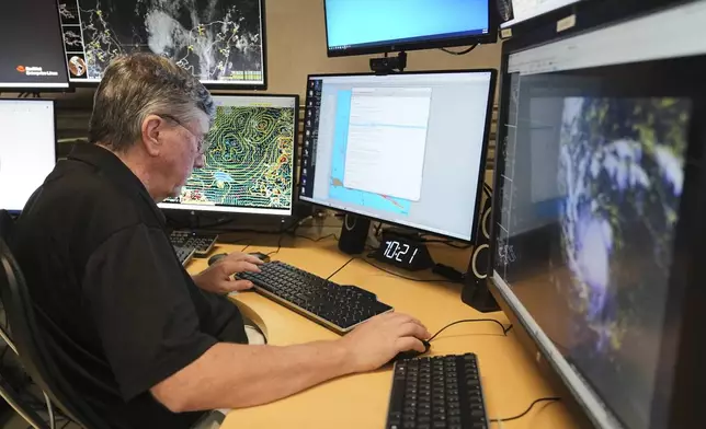 Senior hurricane specialist Jack Bevin prepares an advisory on Tropical Storm Erin at the National Hurricane Center, Thursday, Aug. 14, 2025, in Miami. (AP Photo/Lynne Sladky)