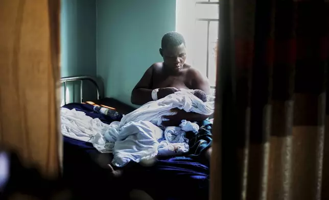 A woman breastfeeds her newborn at Wakiso Health Centre IV in Wakiso, Uganda, Tuesday, July 22, 2025. (AP Photo/Patrick Onen)