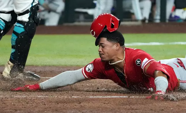 Cincinnati Reds' Noelvi Marte scores after hitting a triple and an error by Arizona Diamondbacks' Geraldo Perdomo in the sixth inning of a baseball game Sunday, Aug 24, 2025, in Phoenix. (AP Photo/Rick Scuteri)