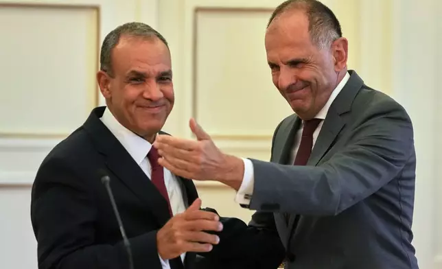 Egyptian Foreign Minister Badr Abdelatty, left, and his Greek counterpart George Gerapetritis shake hands after a news conference in Athens, Greece, Wednesday, Aug. 6, 2025. (AP Photo/Thanassis Stavrakis)
