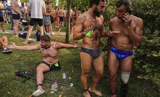 Ukrainian war veterans Oleksandr Dashko, from left, Oleh Tserkovnyi and Pavlo Tovstyk, prepare to compete in a 6.5km swimming race across the Bosporus Strait, from the Asian side to the European side, in Istanbul, Turkey, Sunday, Aug. 24, 2025. (AP Photo/Khalil Hamra)