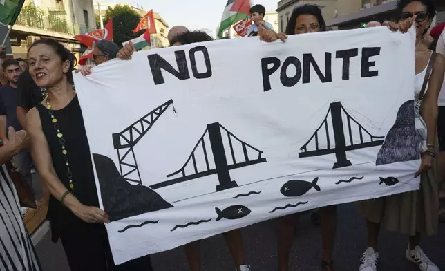 People hold a banner during a demonstration against the bridge in Messina, Italy on Saturday, Aug. 9, 2025 (Francesco Saya/LaPresse via AP)