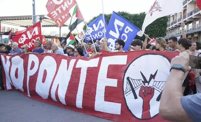 People hold a banner during a demonstration against the bridge in Messina, Italy on Saturday, Aug. 9, 2025 (Francesco Saya/LaPresse via AP)