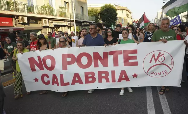 People hold a banner during a demonstration against the bridge in Messina, Italy on Saturday, Aug. 9, 2025 (Francesco Saya/LaPresse via AP)