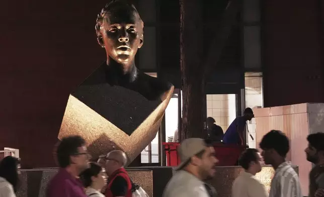 People walk in front of the Althea Gibson statue outside of Arthur Ashe Stadium during the first-round of the U.S. Open tennis championships, Sunday, Aug. 24, 2025, in New York. (AP Photo/Frank Franklin II)