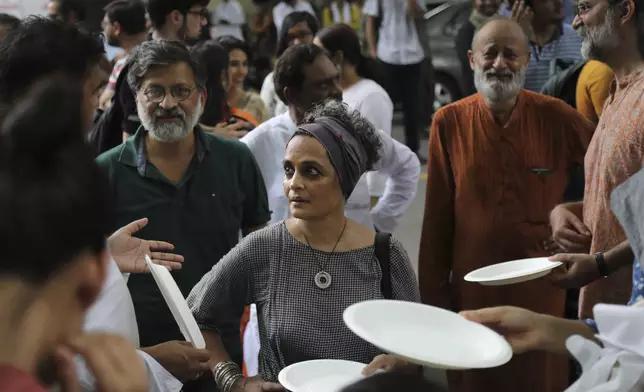 FILE -Booker Prize-winning novelist and activist Arundhati Roy, center, participates in a gathering for Kashmiris to observe Eid al-Adha away from their homes in New Delhi, India, Aug. 12, 2019. (AP Photo/Manish Swarup, File)