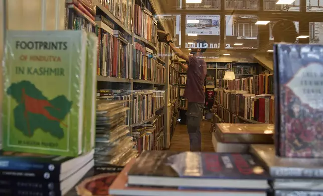 A Kashmiri man looks at a book in a bookstore in Srinagar, Indian controlled Kashmir, Thursday, Aug. 7, 2025. (AP Photo/ Dar Yasin )