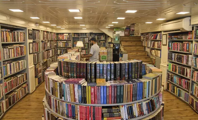 A Kashmiri man arranges books in a bookstore in Srinagar, Indian controlled Kashmir, Thursday, Aug. 7, 2025. (AP Photo/ Dar Yasin )