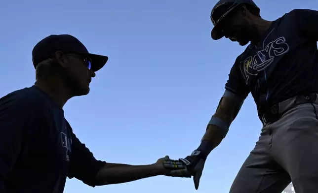 Tampa Bay Rays' Josh Lowe, right, is greeted by Tampa's Kevin Cash after hitting a three-run home run against Washington Nationals pitcher Jake Irvin during the first inning of a baseball game, Saturday, Aug. 30, 2025, in Washington. (AP Photo/Terrance Williams)