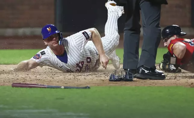 New York Mets first base Pete Alonso (20) is out at home plate as he slides past Atlanta Braves catcher Sean Murphy during the fourth inning of a baseball game, Wednesday, Aug. 13, 2025, in New York. (AP Photo/Heather Khalifa)