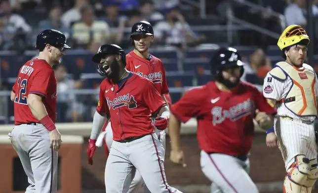 Atlanta Braves' Michael Harris II, center, celebrates his grand slam with Atlanta Braves catcher Sean Murphy (12) while New York Mets catcher Francisco Alvarez looks on during the fourth inning of a baseball game, Wednesday, Aug. 13, 2025, in New York. (AP Photo/Heather Khalifa)