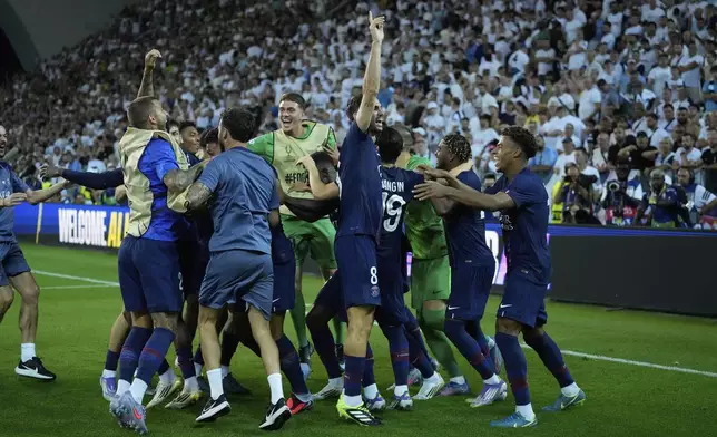PSG players celebrate following a penalty shootout to win the UEFA Super Cup soccer match between Paris Saint-Germain and Tottenham Hotspur in Udine, Italy, Wednesday, Aug. 13, 2025. (AP Photo/Darko Bandic)