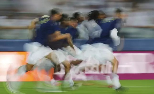 Tottenham's players warm up before the UEFA Super Cup soccer match between Paris Saint-Germain and Tottenham Hotspur in Udine, Italy, Wednesday, Aug. 13, 2025. (AP Photo/Antonio Calanni)