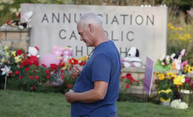 Mike Bower visits a make-shift memorial at Annunciation Catholic Church after the Wednesday's shooting at the school, Friday, Aug. 29, 2025, in Minneapolis. (AP Photo/Bruce Kluckhohn)