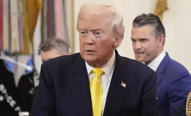 Defense Secretary Pete Hegseth, right, watches as President Donald Trump departs an event to mark National Purple Heart Day in the East Room of the White House, Thursday, Aug. 7, 2025, in Washington. (AP Photo/Mark Schiefelbein)