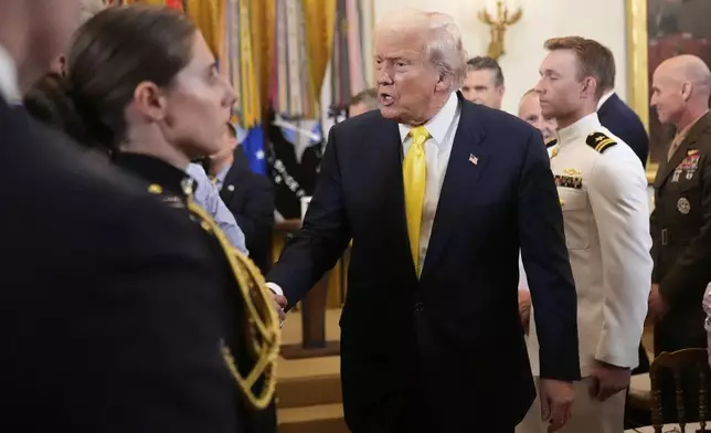 President Donald Trump greets attendees as he departs an event to mark National Purple Heart Day in the East Room of the White House, Thursday, Aug. 7, 2025, in Washington. (AP Photo/Mark Schiefelbein)
