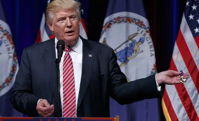 FILE - Republican presidential candidate Donald Trump holds a Purple Heart medal given to him by a supporter during a campaign rally, Aug. 2, 2016, in Ashburn, Va. (AP Photo/Evan Vucci, File)