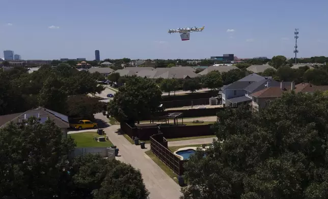 A drone flies over a neighborhood as it arrives at a home with a delivery, Thursday, July 31, 2025, in Frisco, Texas. (AP Photo/Julio Cortez)