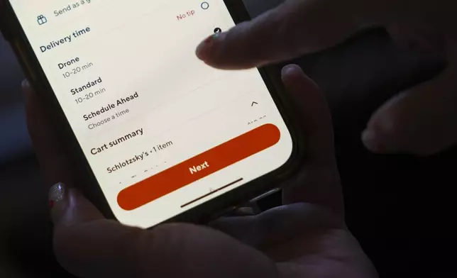 Janet Toth selects a drone delivery option while placing an order through the DoorDash application on a phone Thursday, July 31, 2025, in Frisco, Texas. (AP Photo/Julio Cortez)