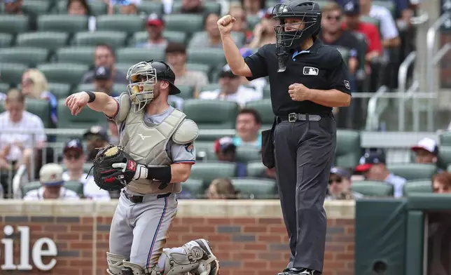 Home plate umpire Jen Pawol signals a strikeout in the third inning of a baseball game between the Miami Marlins and Atlanta Braves, Sunday, Aug. 10, 2025, in Atlanta. (AP Photo/Colin Hubbard)