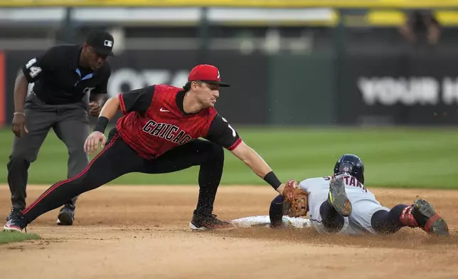 Chicago White Sox shortstop Colson Montgomery, second from left, tags out Cleveland Guardians' Carlos Santana, right, at second base during the third inning of a baseball game Friday, Aug. 8, 2025, in Chicago. (AP Photo/Erin Hooley)