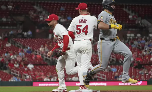 Pittsburgh Pirates' Spencer Horwitz, right, reaches base on a throwing error by St. Louis Cardinals first baseman Willson Contreras, left, as Cardinals starting pitcher Sonny Gray (54) watches during the sixth inning of a baseball game Wednesday, Aug. 27, 2025, in St. Louis. (AP Photo/Jeff Roberson)