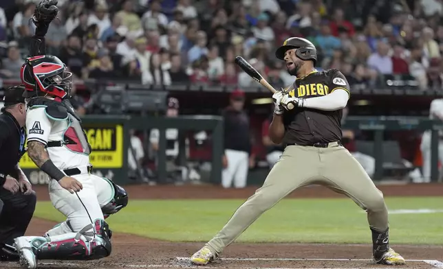 San Diego Padres' Elias Díaz, right, backs away from an inside pitch as Arizona Diamondbacks catcher Jose Herrera, left, makes the catch during the second inning of a baseball game Tuesday, Aug. 5, 2025, in Phoenix. (AP Photo/Ross D. Franklin)