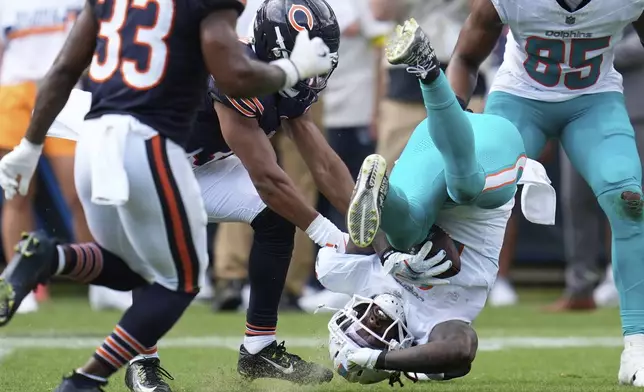 Miami Dolphins running back Alexander Mattison (8) falls to the field during the second half of an NFL preseason football game against the Chicago Bears, Sunday, Aug. 10, 2025, in Chicago. (AP Photo/Erin Hooley)