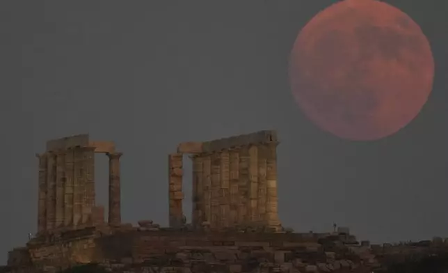 A Full Sturgeon Moon rises behind the ancient temple of Poseidon at Cape Sounion, about 70 kilometers (45 miles) south of Athens, Greece, Friday, Aug. 8, 2025. (AP Photo/Thanassis Stavrakis)