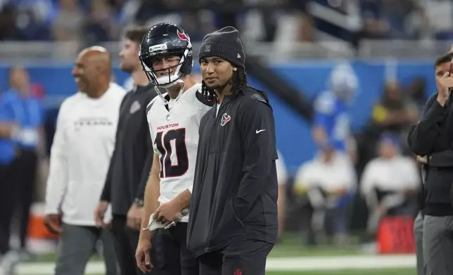Houston Texans quarterbacks Davis Mills (10) and C.J. Stroud stand together before a preseason NFL football game against the Detroit Lions Saturday, Aug. 23, 2025, in Detroit. (AP Photo/Paul Sancya)