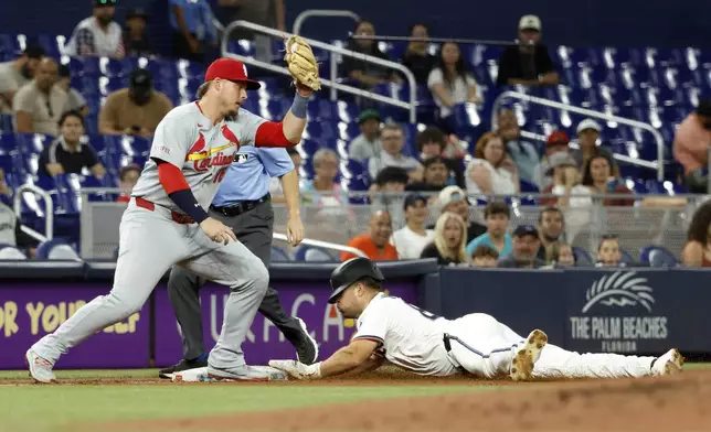 Miami Marlins' Jakob Marsee, right, steals third base in front of St. Louis Cardinals' third baseman Nolan Gorman during the third inning of a baseball game, Wednesday, Aug. 20, 2025, in Miami. (AP Photo/Rhona Wise)