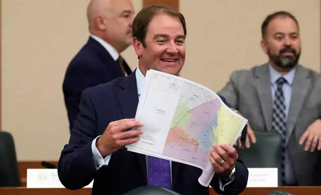 Texas state Rep. John McQueeney, R-Fort Worth, looks through U.S. Congressional District maps during a redistricting hearing at the Texas Capitol, Thursday, July 24, 2025, in Austin, Texas. (AP Photo/Eric Gay)