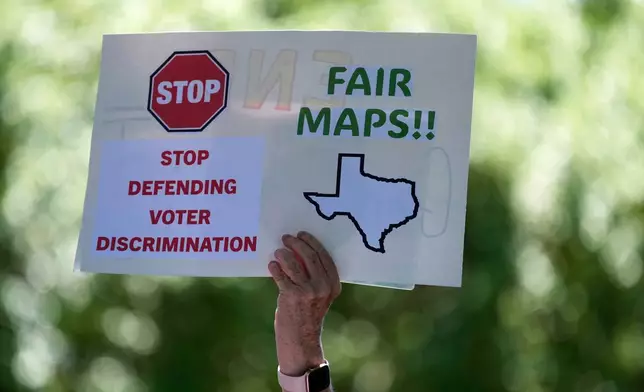 A woman holds a sign during a rally to protest against redistricting hearings at the Texas Capitol, Thursday, July 24, 2025, in Austin, Texas. (AP Photo/Eric Gay)