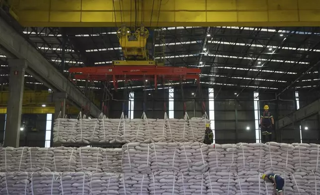 Workers prep bulk bags of sugar to be loaded on a container ship at the port of Santos, Brazil, Tuesday, July 29, 2025. (AP Photo/Andre Penner)