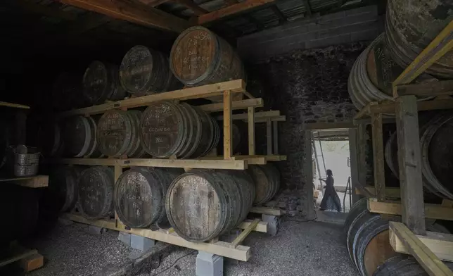 Amy Pasquet co-owner of Jean-Luc Pasquet Cognac, walks by barrels of Cognac in Bellevigne, near Cognac, southwestern France, Wednesday, July 23, 2025. (AP Photo/Michel Euler)