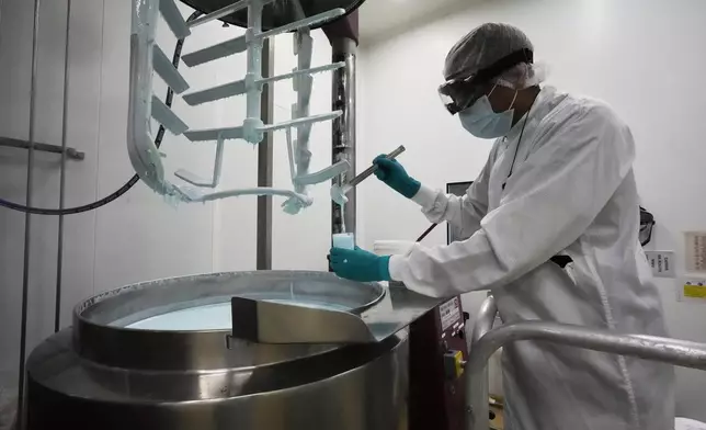 A worker checks the results of a cosmetic cream at the French cosmetics company Yon-Ka Paris in Argenteuil, outside Paris, Thursday, July 31, 2025. (AP Photo/Michel Euler)