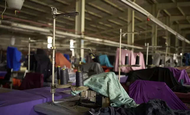 A sewing machine is covered by a sheet inside the empty Tzicc clothing factory following the threat of U.S.-imposed tariffs in Maseru, Lesotho, Tuesday, July 22, 2025. (AP Photo/Bram Janssen)