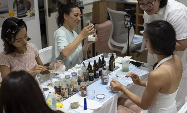 Customers and influencers try on new Korean perfume during a workshop at Senti Senti in New York on Friday, July 25, 2025. (AP Photo/Yuki Iwamura)