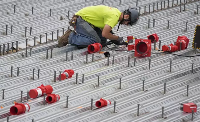 A worker assembles steel decking in the construction of a housing project, Thursday, July 31, 2025, in Portland, Maine. (AP Photo/Robert F. Bukaty)