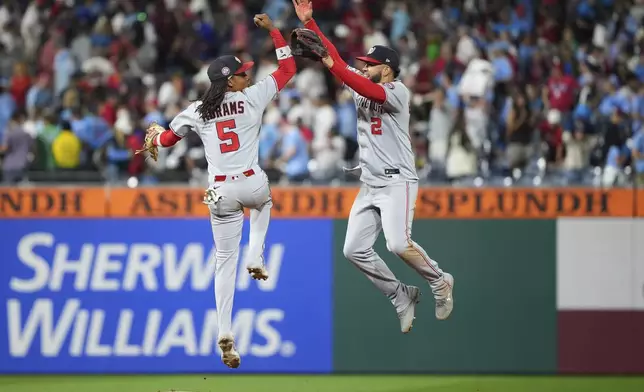 Washington Nationals' Luis García Jr., right, and CJ Abrams celebrate after the Nationals won a baseball game against the Philadelphia Phillies Friday, Aug. 22, 2025, in Philadelphia. (AP Photo/Matt Slocum)
