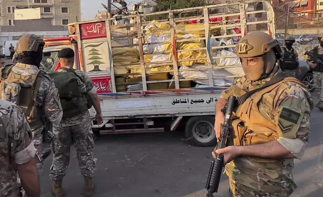 Army soldiers stand next to a pickup carrying weapons handed over by Palestinian factions at the Burj al-Barajneh Palestinian refugee camp in Beirut, Lebanon, Thursday, Aug. 21, 2025, in an initial step to implement a plan officials announced three months earlier for removing arms from the camps. (AP Photo/Hussein Malla)