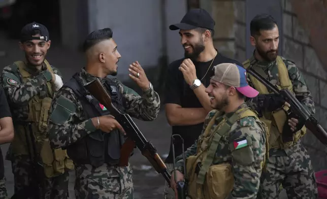 Palestinian gunmen from the National Security Forces, stand at the entrance of Burj al-Barajneh Palestinian refugee camp where Palestinian factions handed over weapons to the Lebanese army, in Beirut, Thursday, Aug. 21, 2025. (AP Photo/Hussein Malla)