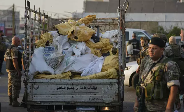Lebanese army soldiers stand next of a pickup loaded with weapons handed over by Palestinian factions at the Burj al-Barajneh Palestinian refugee camp in Beirut, Lebanon, Thursday, Aug. 21, 2025, in an initial step to implement a plan officials announced three months earlier for removing arms from the camps. (AP Photo/Hussein Malla)