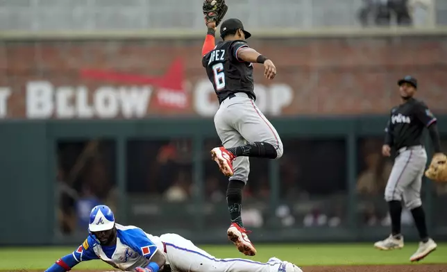 Atlanta Braves' Michael Harris II (23) steals second base against Miami Marlins' Otto Lopez (6) in the second inning in the second baseball game of a doubleheader, Saturday, Aug. 9, 2025, in Atlanta. (AP Photo/Mike Stewart)