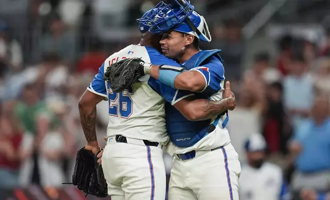 Atlanta Braves pitcher Raisel Iglesias (26) and catcher Drake Baldwin (30) celebrate a win over the Miami Marlins after the second baseball game of a doubleheader, Saturday, Aug. 9, 2025, in Atlanta. (AP Photo/Mike Stewart)