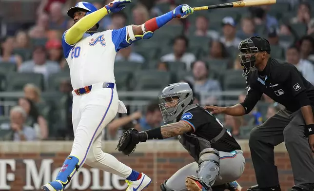 Atlanta Braves designated hitter Marcell Ozuna (20) hits a solo home run against the Miami Marlins in the fourth inning in the second baseball game of a doubleheader, Saturday, Aug. 9, 2025, in Atlanta. (AP Photo/Mike Stewart)