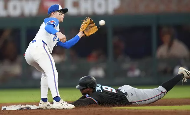 Miami Marlins' Xavier Edwards (9) slides safe into second base against Atlanta Braves shortstop Nick Allen (2) in the fourth inning in the second baseball game of a doubleheader, Saturday, Aug. 9, 2025, in Atlanta. (AP Photo/Mike Stewart)
